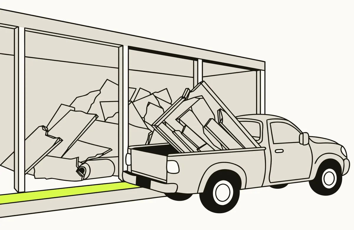A pickup truck unloading boards and drywall at a transfer station.